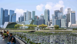 File photo for representational purposes showing people sitting next to a pond outside ArtScience museum at Marina bay in Singapore on September 8, 2026. (Photo by Roslan RAHMAN / AFP)