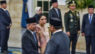 Indonesia's President Prabowo Subianto (R) shakes hands with newly appointed Finance Minister Suahasil Nazara (L) past his wife Christina Pusporini Messakh (C) during a swearing-in ceremony at the presidential palace in Jakarta on September 14, 2026, following a cabinet reshuffle. Indonesian president Prabowo Subianto removed Finance Minister Purbaya Yudhi Sadewa from his position, naming his deputy as the new minister. (Photo by FATIH MUBAROK / AFP)