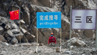 A rescuer from China Anneng observes the surrounding area when searching for survivors at the core affected zone of the mudslide-hit Gyirong Port in southwest China's Xizang Autonomous Region, Sept. 6, 2026. (Xinhua/Tenzin Nyida)