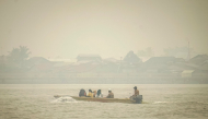 People travel on a river boat as thick haze from forest and land fires blankets Benua Melayu Darat village in Pontianak, West Kalimantan, on September 16, 2026. (Photo by DITO / AFP)