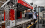 A man wearing a rain jacket stands in front of a booth promoting the 2026 Asian Games in Nagoya, Aichi Prefecture on September 16, 2026. (Photo by Mohd Rasfan / AFP)
