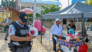 A member of the Mexican National Guard makes an announcement to residents and visitors about the approach of Hurricane Polo along a beach in Acapulco, Guerrero state, Mexico, on September 21, 2026. (Photo by Francisco Robles / AFP)