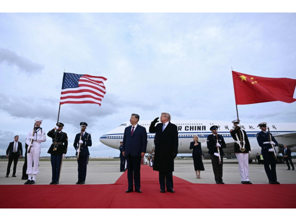 US President Donald Trump reacts after a B1 bomber flew past during the national anthems while he greeted Chinese President Xi Jinping upon his arrival at Joint Base Andrews in Maryland on September 23, 2026. (Photo by Brendan Smialowski / AFP)