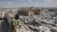 A man standing on top of a building looks at tents of displaced Palestinians in Al-Mawasi area of Khan Yunis in the southern Gaza Strip on September 25, 2026. (Photo by BASHAR TALEB / AFP)