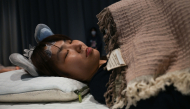 An attendee takes part in a sleep competition organized by a mattress brand in Tokyo on October 5, 2026. (Photo by Selim Chtayti / AFP)