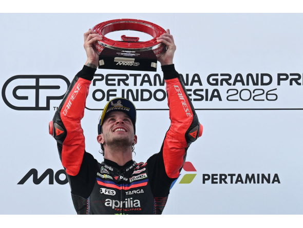 Aprilia Racing Italian rider Marco Bezzecchi celebrates on the podium after winning the MotoGP Indonesian Grand Prix at the Mandalika International Circuit in Mandalika on October 11, 2026. (Photo by SONNY TUMBELAKA / AFP)