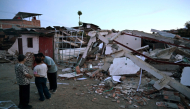 People gather in front of a house damaged by an earthquake in Colombia. AFP file photo.