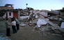 People gather in front of a house damaged by an earthquake in Colombia. AFP file photo.