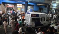 An ambulance carrying Durga Puja Pandal stampede victims stops in front of the emergency building of Calcutta Medical College and Hospitalas relatives of Durga Puja Pandal stampede victims mourn in Kolkata on October 16, 2026. (Photo by AFP)