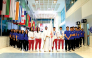 Equestrian rider Jassim Al Kuwari holds the Asian Games Flag alongside Team Qatar’s padel and women’s basketball players and students at the University of Doha for Science and Technology.