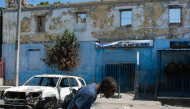 Man leaving prison area while lowering his head due to nearby gunfire in Port-au-Prince, Haiti. AFP file photo.