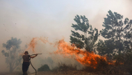 A firefighter battles a fast-moving brush fire amidst heavy smoke in Tegal Arum, Banjarbaru, South Kalimantan, on October 20, 2026. Photo by MUDA SAGALA / AFP