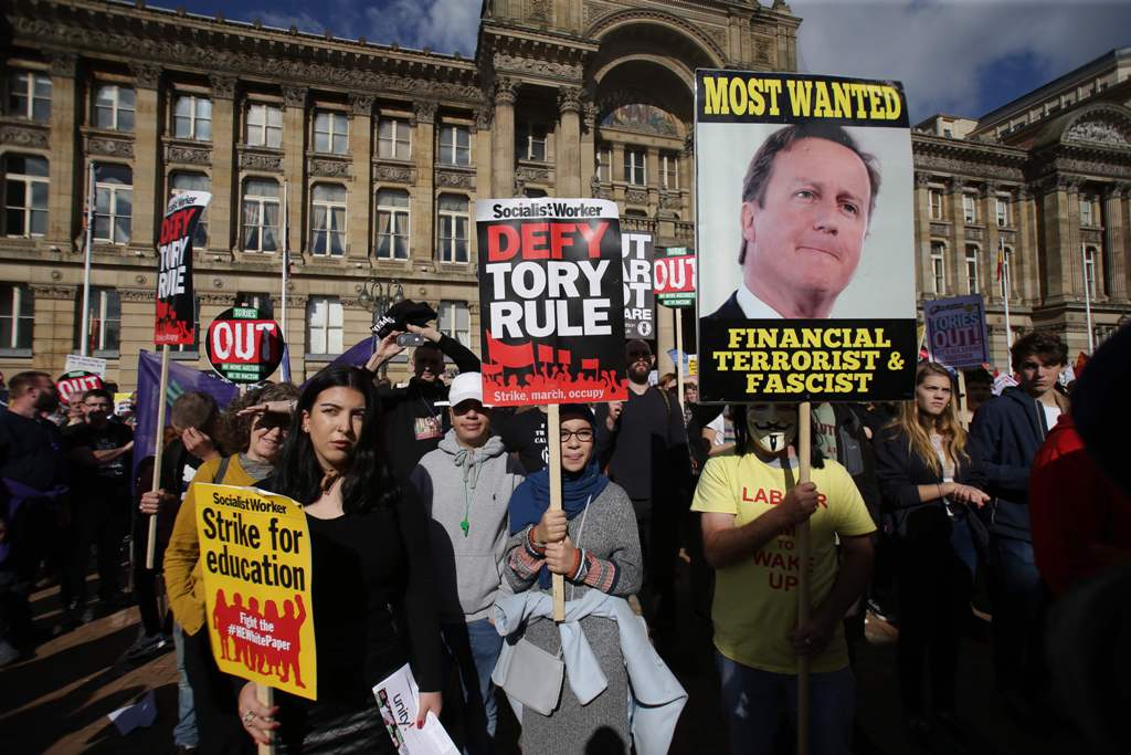 Anti-conservative protesters hold placards during a rally in Victoria Square in Birmingham, central England, on October 2, 2016 on the first day of the Conservative party annual conference.  AFP / DANIEL LEAL-OLIVAS
