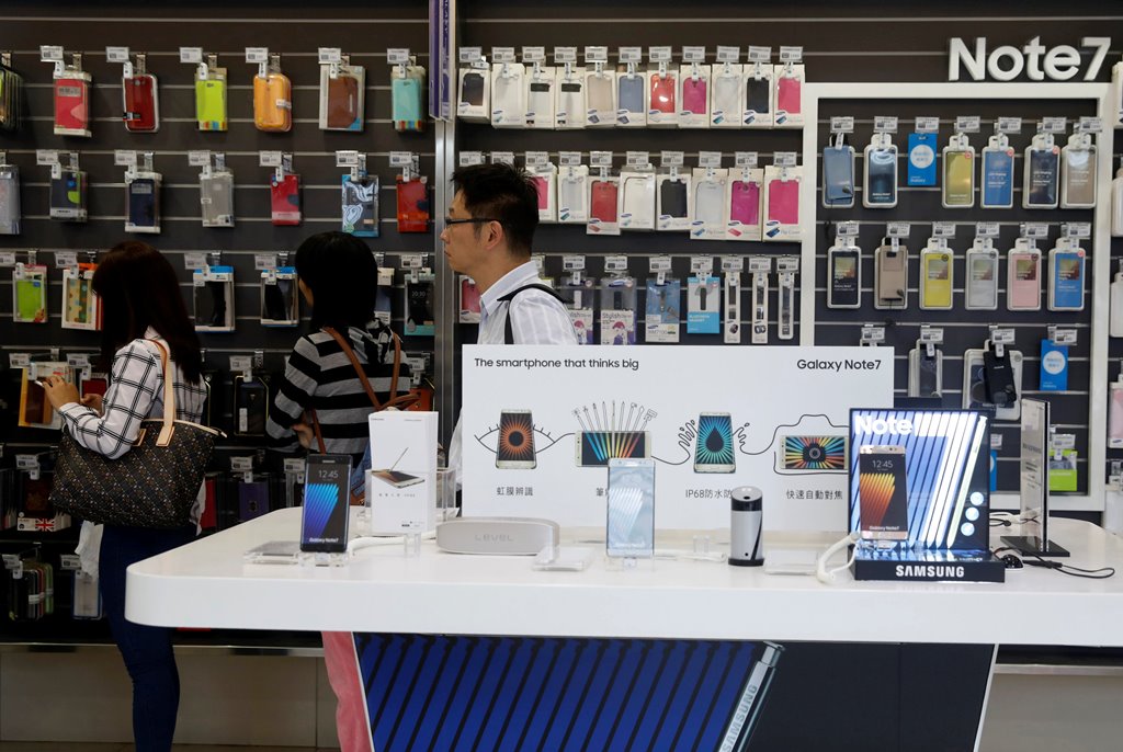 Customers queue near Galaxy Note 7 smartphone advertisements at a Samsung service centre in Taipei, Taiwan October 11, 2016. REUTERS/Tyrone Siu