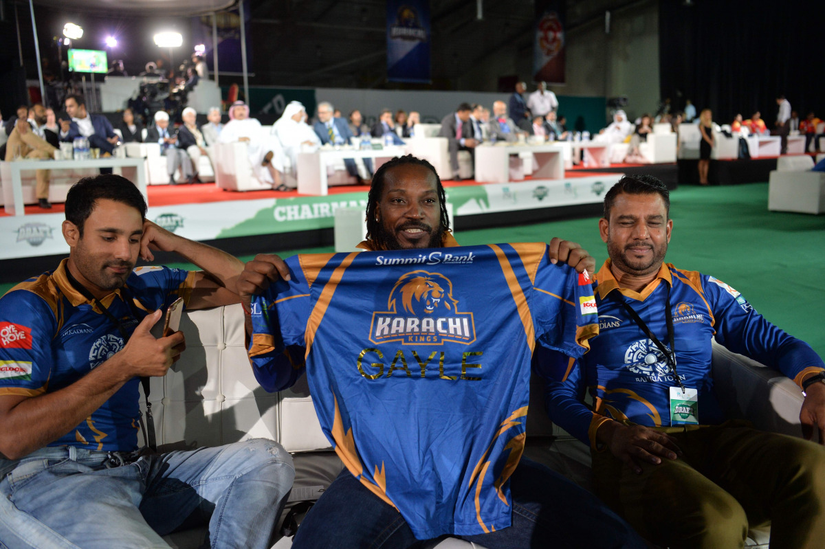 Pakistan Super League (PSL) team Karachi Kings player Chris Gayle (C) holds team shirt during second edition of PSL draft in Dubai on October 19, 2016.
PSL which will be held in United Arab Emirates in February-March 2017. (AFP / Aamir Qureshi)