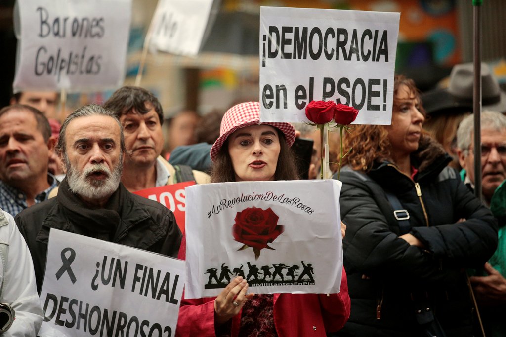 Supporters of Spain's Socialist party (PSOE) hold red roses and posters reading 