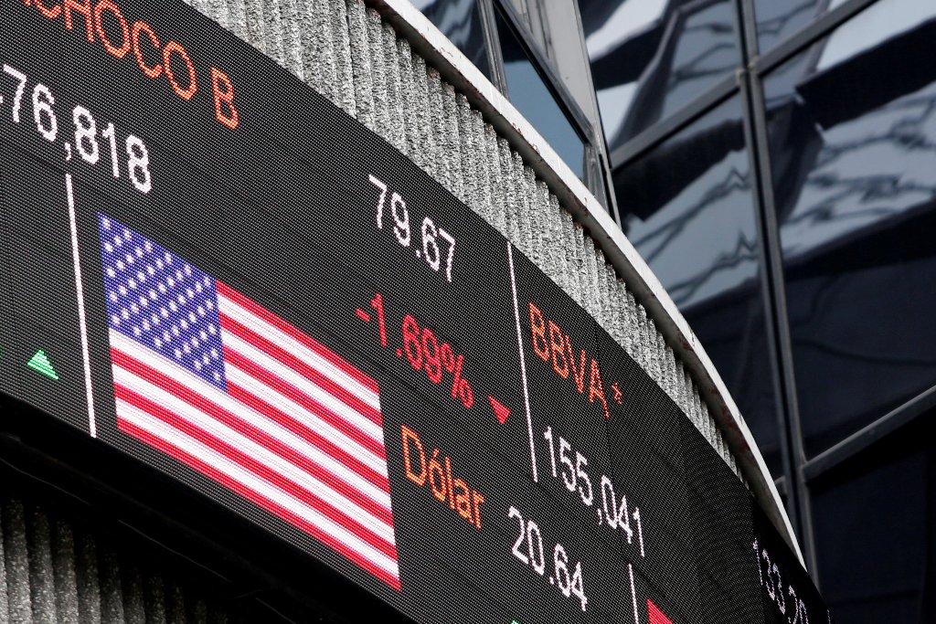 A screen displaying the exchange rate for Mexican peso and U.S. dollars next to the U.S flag is seen at Mexican stock market building in Mexico City, Mexico November 11, 2016. REUTERS/Carlos Jasso
