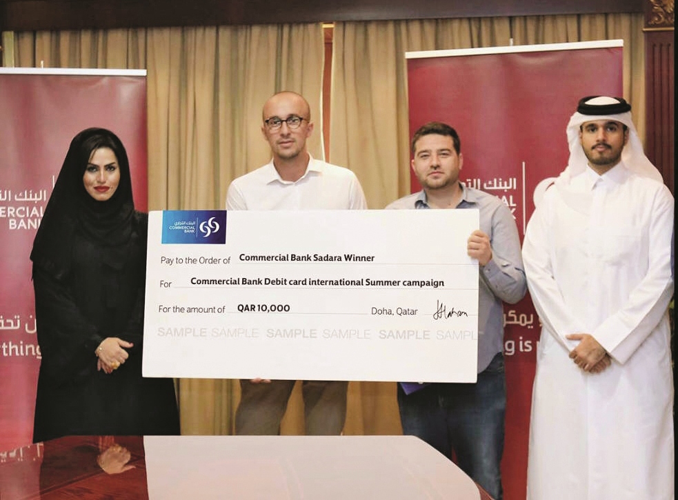 Commercial Bank officials with winners of the summer campaign.