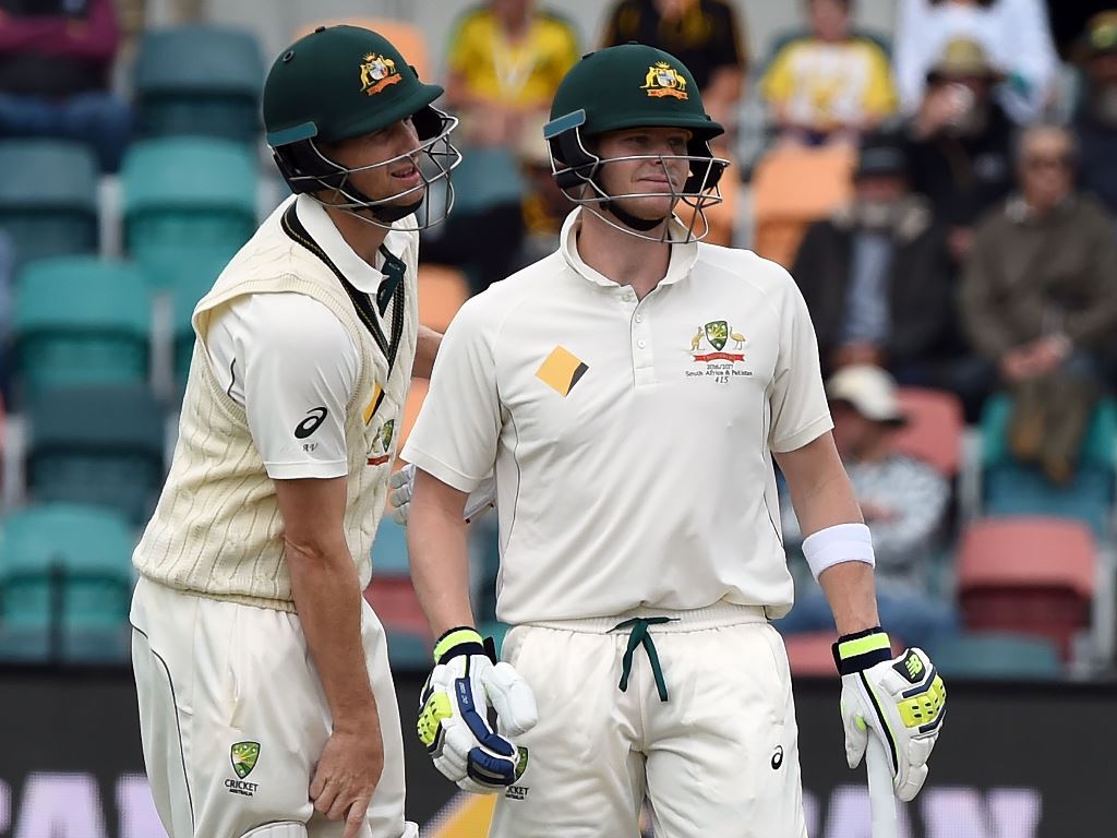 This file photo taken on November 15, 2016 shows Australia's batsman Adam Voges (L) waiting for the third umpire's decision with team captain Steven Smith on the fourth day of play in the second Test cricket match between Australia and South Africa in Hob