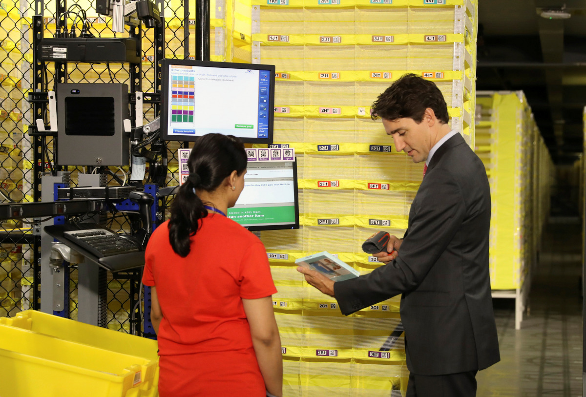 Canada Prime Minister Justin Trudeau scans merchandise with an employee during a tour of the Amazon Fulfillment Centre in Brampton, Ontario, Canada, October 20, 2016. (REUTERS / Fred Thornhill)
