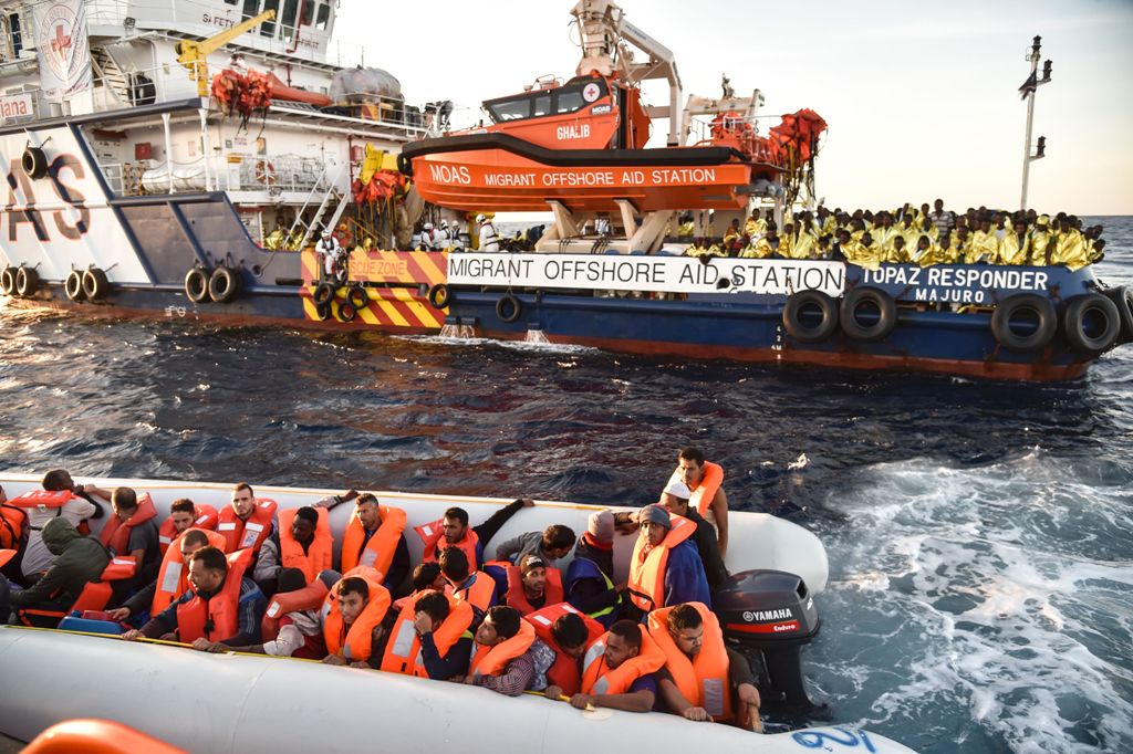 This file photo taken on November 5, 2016 shows members of Maltese NGO MOAS helping people to board a small rescue boat during a rescue operation of migrants and refugees by the Topaz Responder ship run by Moas and the Red Cross, on November 5, 2016 off t