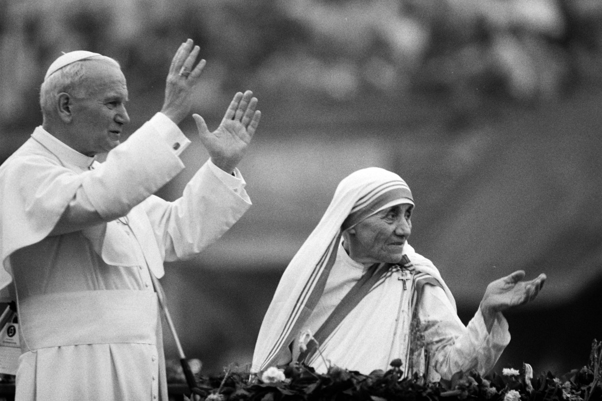 This February 03 1986 photo shows Mother Teresa and Pope John Paul II waving to well-wishers at the Nirmal Hriday Home in Calcutta (AFP JEAN-CLAUDE DELMAS)