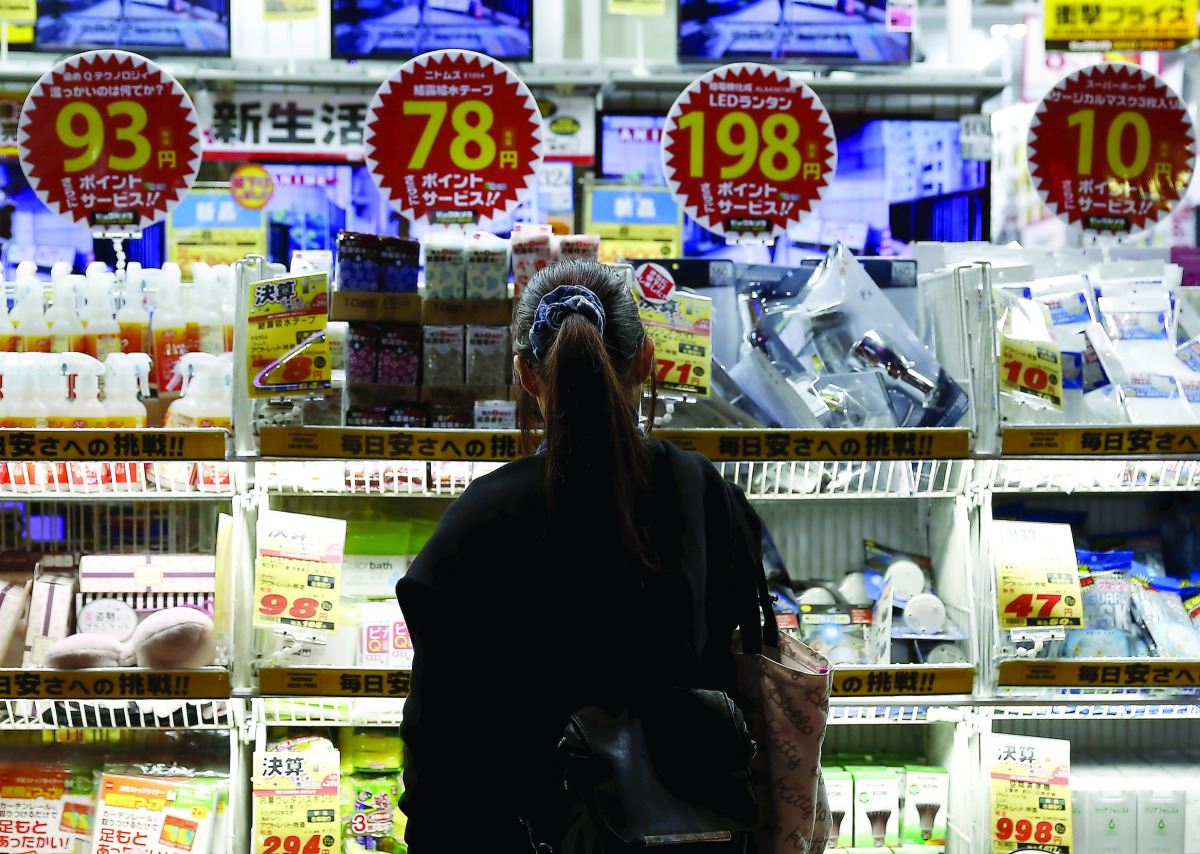 A woman looks at items outside an outlet store at a shopping district in Tokyo.
