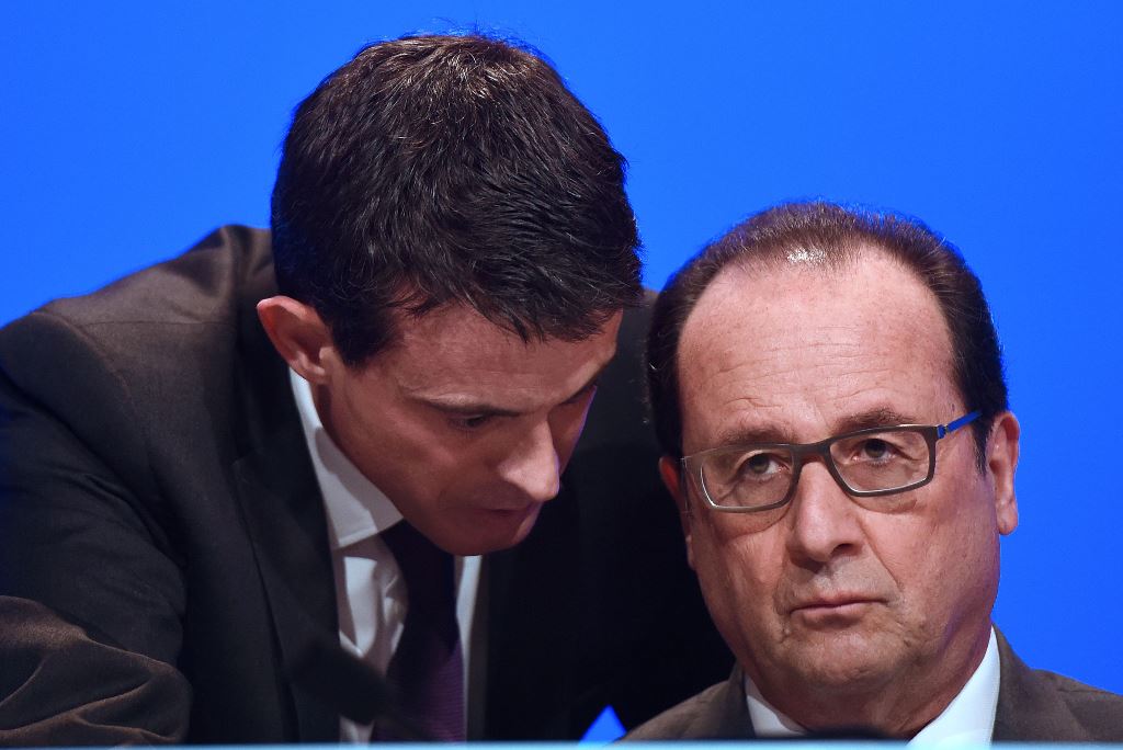 (FILES) This file photo taken on November 18, 2015 shows French Prime Minister Manuel Valls (L) speaking to French President Francois Hollande before he delivers a speech during a meeting of French mayors in Paris. AFP / POOL / STEPHANE DE SAKUTIN
