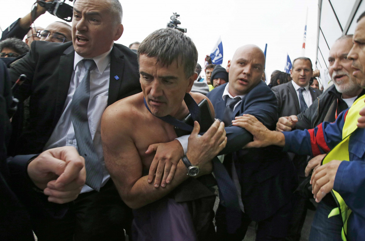 File photo of a shirtless Xavier Broseta (2ndL), Executive Vice President for Human Resources and Labour Relations at Air France, who was evacuated by security after employees interrupted a meeting with representatives staff at the Air France headquarters