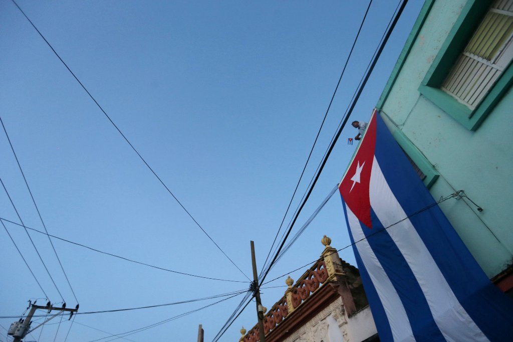 A man stands on a roof while waiting for the ashes of Cuba's former President Fidel Castro to pass during a journey to the eastern city of Santiago de Cuba, in Bayamo, Cuba, December 2, 2016. REUTERS/Edgard Garrido
