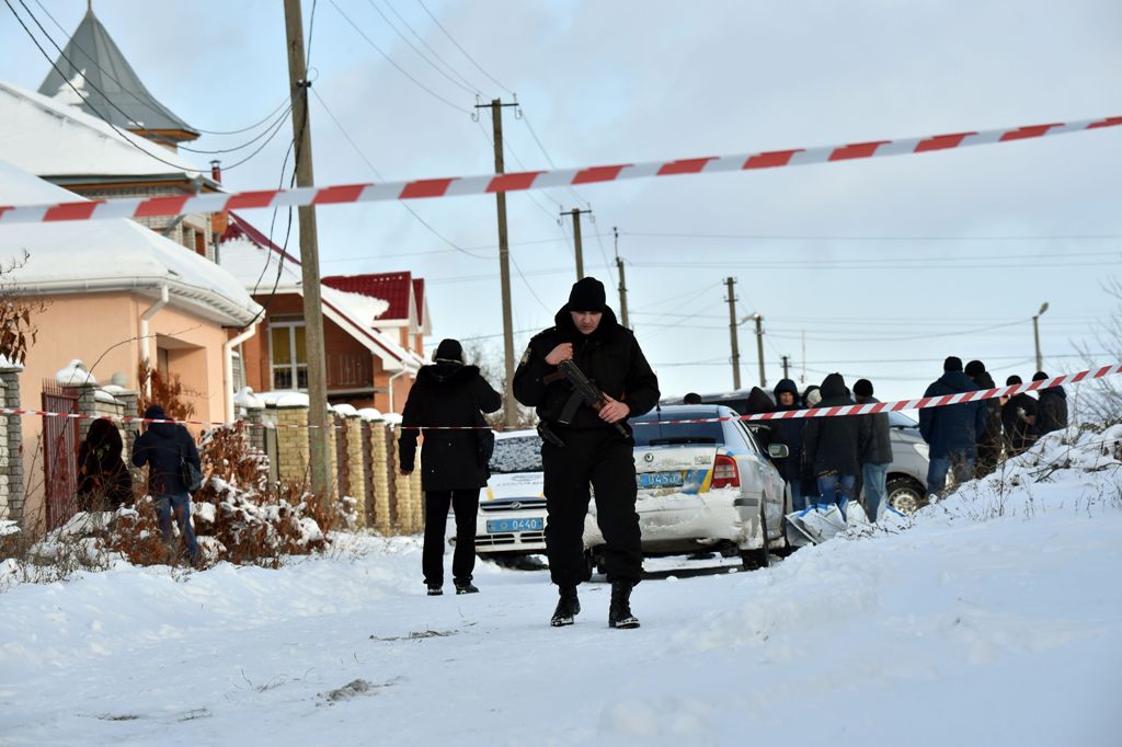 An armed policeman guards as the police experts examine crime scene in the small town of Knyazychy, some 30 kilometres east of Kiev, on December 4, 2016.
Five Ukrainian police were killed by friendly fire on December 4, 2016 in a deadly accident at a cri