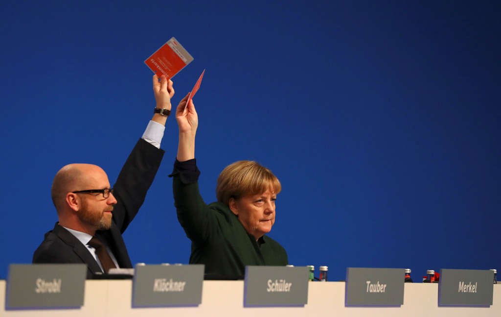 German Chancellor and leader of the conservative Christian Democratic Union party CDU Angela Merkel and CDU secretary general Peter Tauber (L) vote during the CDU party convention in Essen, Germany, December 7, 2016. REUTERS/Kai Pfaffenbach
