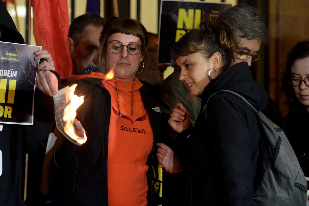 City councillor of Barcelona's city hall and member of radical left-wing Catalan independentist political party CUP (Popular Unity Candidates) Maria Robira (R) and CUP's deputy Mireia Vehi burn a picture of Spain's King during an anti-monarchy demonstrati