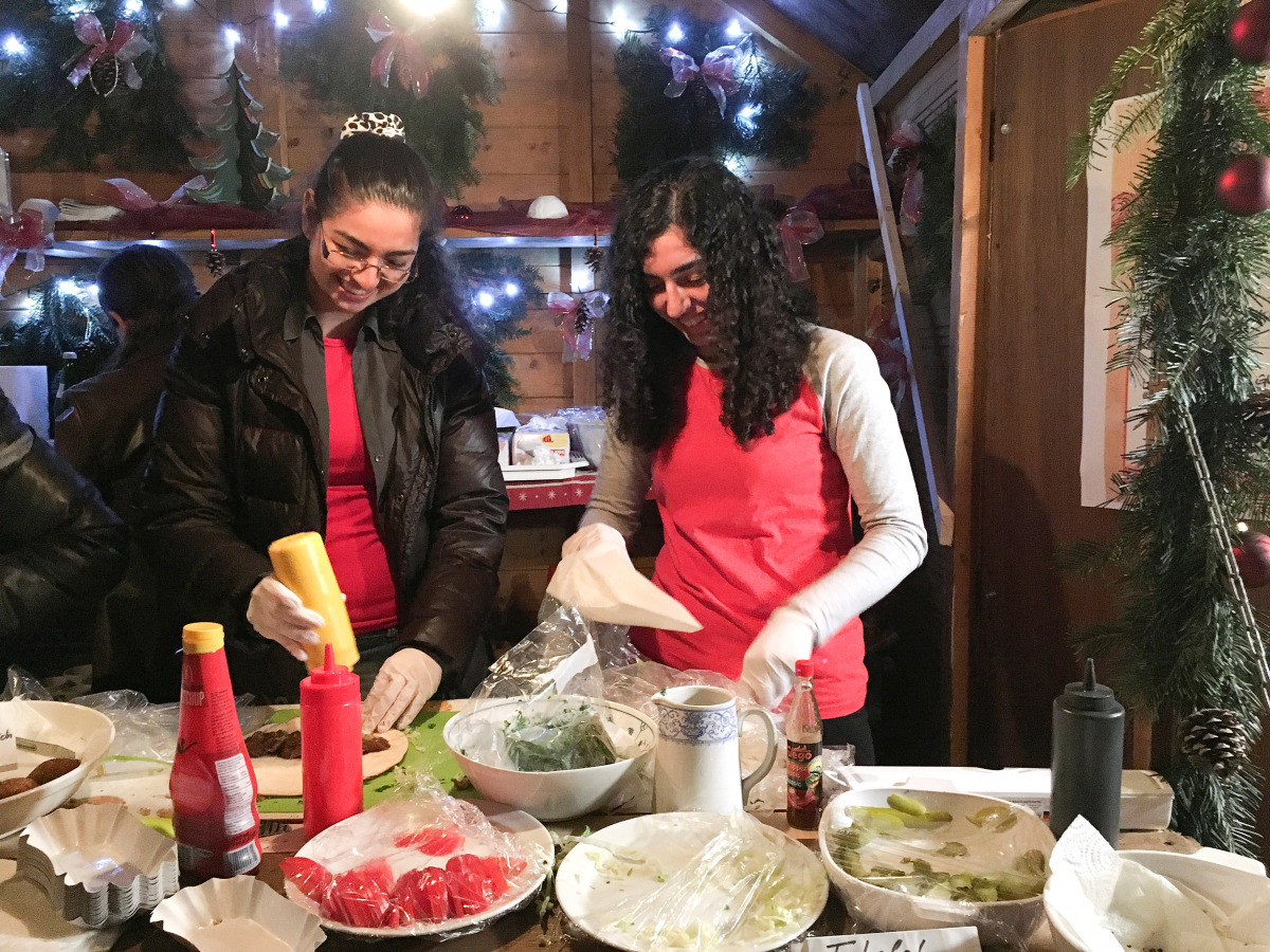 Syrian refugees Mayar and Nawar Ballish serve falafel sandwiches at a traditional German Christmas market in the small Bavarian town of Schillingsfuerst, Germany November 11, 2016. REUTERS/Michelle Martin