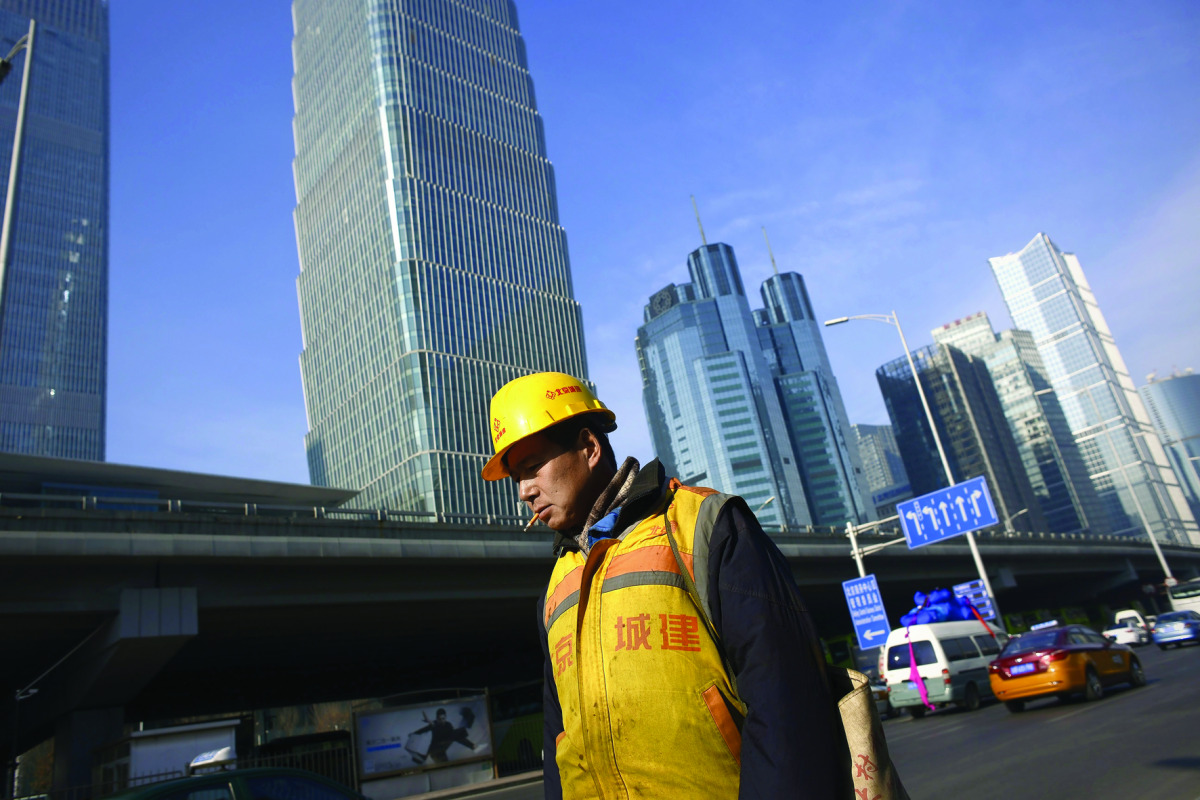 A worker walks outside a construction site in Beijing.