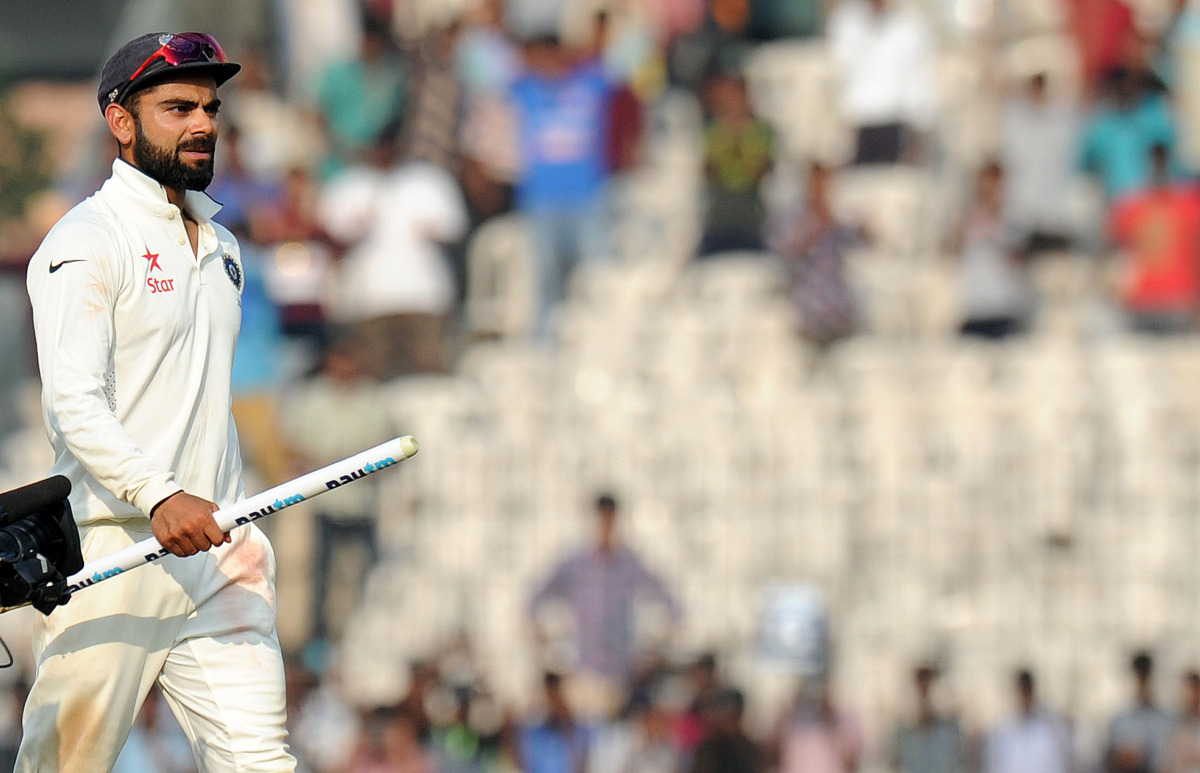 Indian cricket captain Virat Kohli walks with a wicket post after winning the fifth and final Test cricket match between India and England at the M.A. Chidambaram Stadium in Chennai on December 20, 2016. (AFP / ARUN SANKAR)