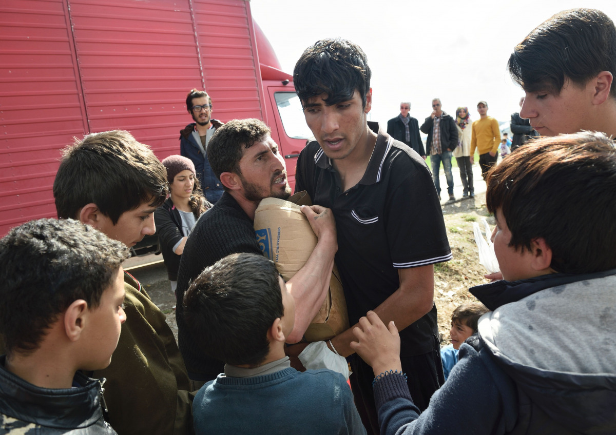 Migrants argue for a box of supplies donated by Greek people on March 11 2016 in a makeshift camp at the Greek-Macedonian border near the Greek village of Idomeni (AFP / DANIEL MIHAILESCU) 