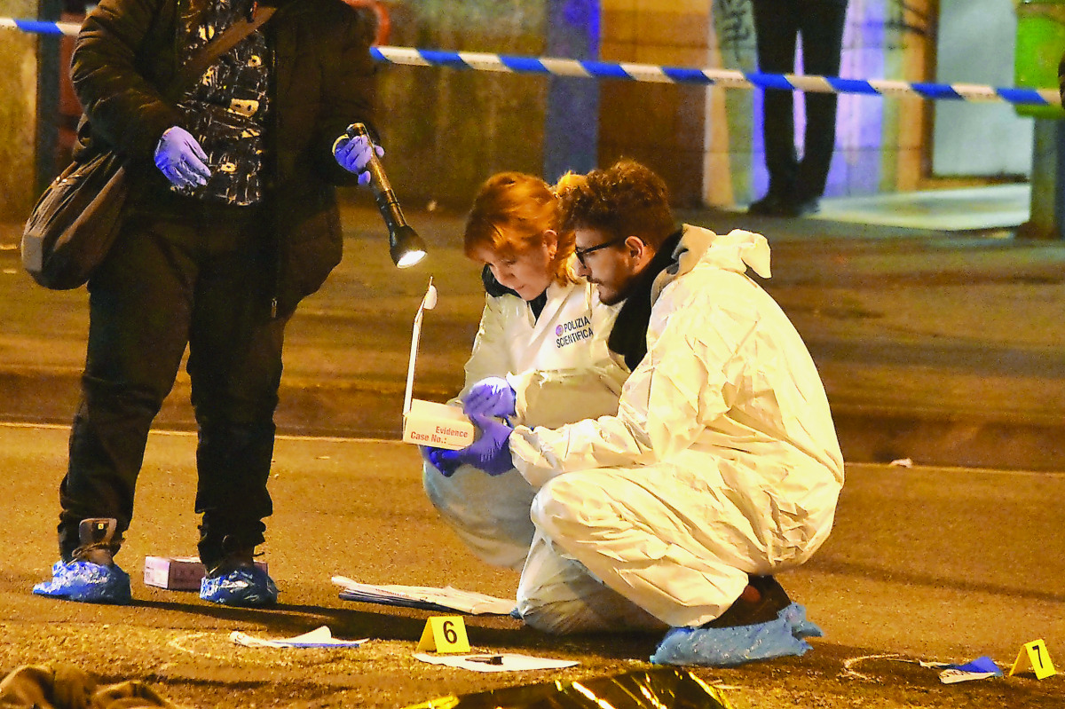 Italian Police officers work next to the body of Anis Amri in a suburb of the northern city of Milan