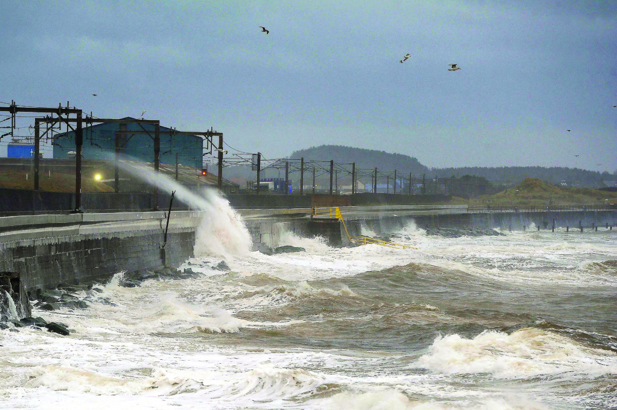 Waves crash onto the traintracks near Saltcoats in Ayrshire, Scotland, as Storm Barbara begins to hit the British coastline