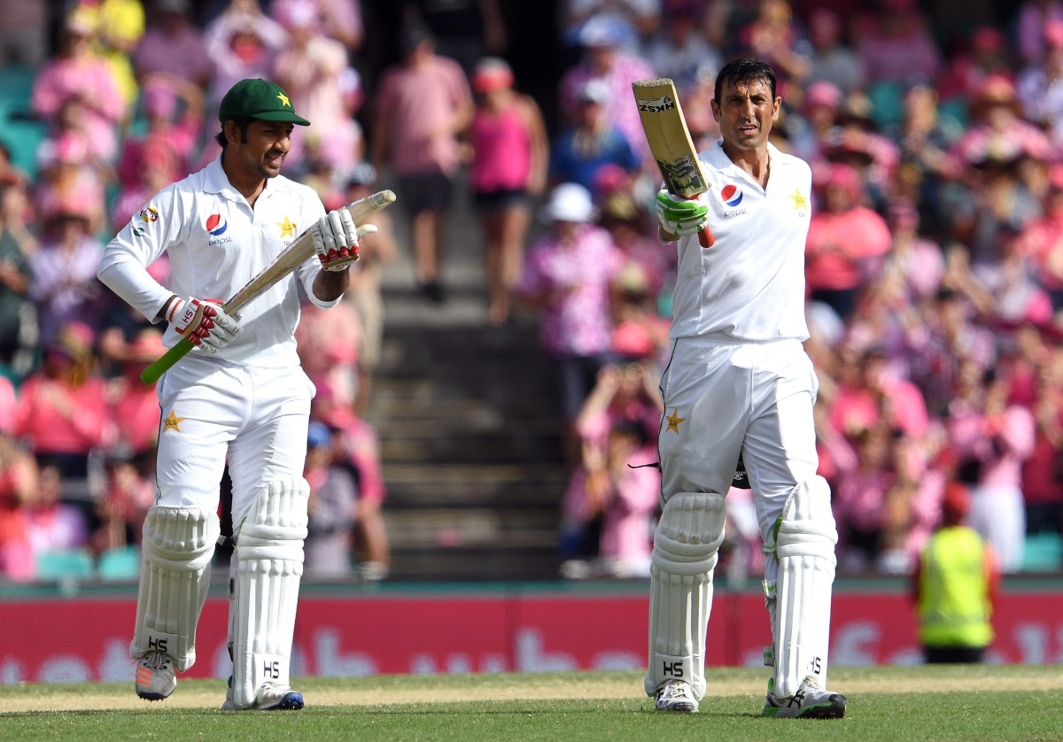 Pakistan batsman Younis Khan (R) celebrates scoring his century against Australia as teammate Sarfraz Ahmed (L) applauds during the third day of the third cricket Test match at the SCG in Sydney on January 5, 2017. (AFP / WILLIAM WEST )
