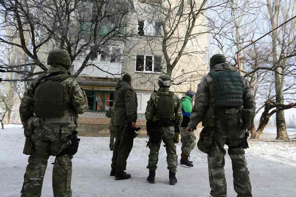 Ukrainian servicemen look at a building destroyed as a result of night shelling by pro-Russian separatists to the flashpoint eastern town of Avdiivka, north of the pro-Russian rebels' de facto capital of Donetsk, on February 3, 2017. AFP / Aleksey FILIPPO