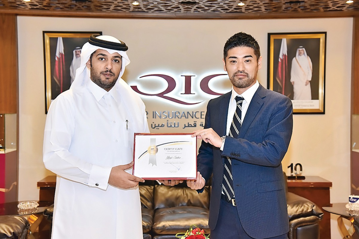 Salem Al Mannai (left), Deputy Group President & CEO of QIC MENA region, handing over certificate of appreciation to trainee Yuji.