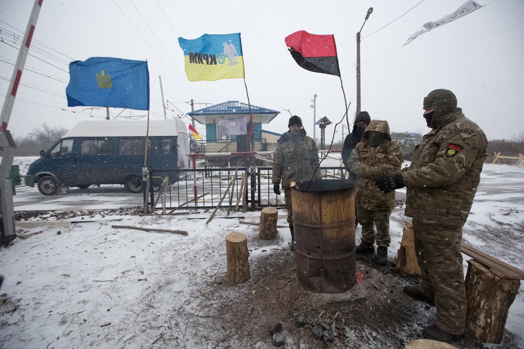 Activists warm themselves at a fire in a camp at Kryvyi Torets station as they take part in a rail blockade that has halted coal supplies in the village of Shcherbivka in Donetsk region, Ukraine, February 14, 2017.  REUTERS/Konstantin Chernichkin