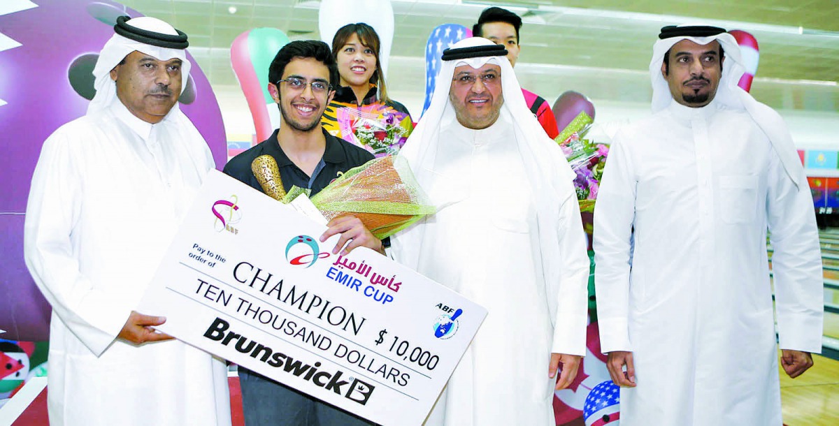 Jassim Al Muraikhi of Qatar, winner in the Emir Cup 2017, poses for a picture along with the winner's cheque and bowling officials on Sunday at the Qatar Bowling Center in Doha.