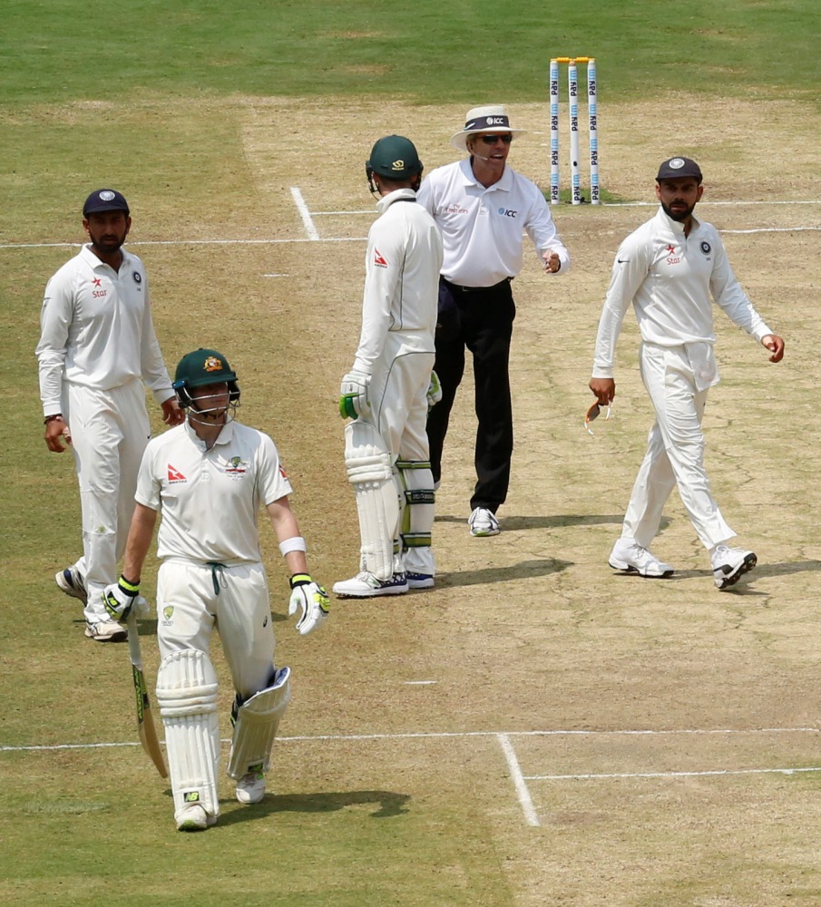 India's captain Virat Kohli (R) speaks to the umpire as Australia's captain Steven Smith (2nd L) walks off the ground after being dismissed. (REUTERS/Danish Siddiqui)