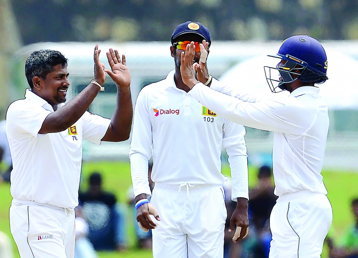 Sri Lankan cricketer Rangana Herath (left) celebrates with his team-mates after he dismissed Bangladesh's Taskin Ahmed during the final day of their opening Test in Galle yesterday. 
