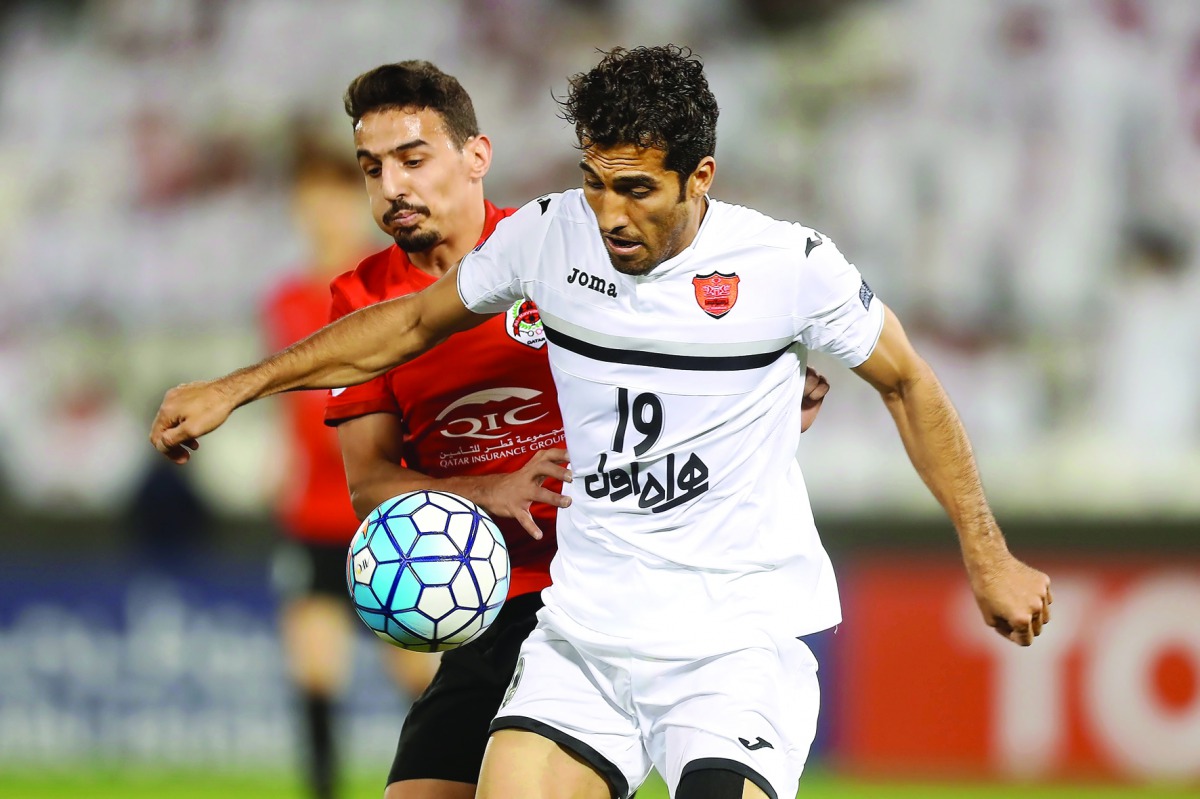 Persepolis' Vahid Amiri (front) fights for the ball during the Asian Champions League football match against Qatar's Al Rayyan at Jassim Bin Hamad Stadium in Doha