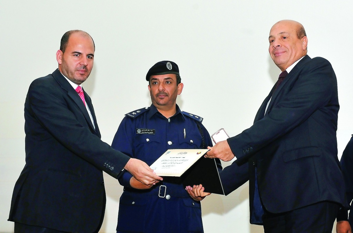 Lt Col Saad Salem Al Dousari (centre), Assistant Director of Human Rights Department at the Ministry of Interior, presenting a certificate of appreciation to members of various communities during celebrations of Arab Human Rights Day, at the Civil Defense