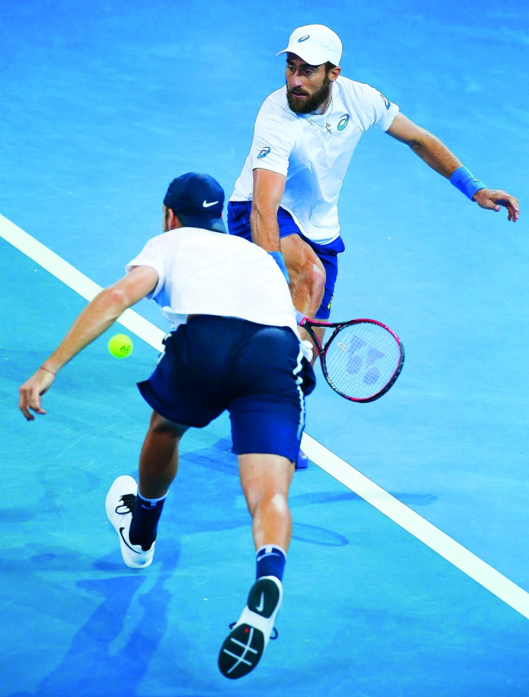 Steve Johnson (top) and Jack Sock (bottom) of the US play a shot against Sam Groth and John Peers of Australia in their doubles match of their world group quarter-final Davis Cup clash at the Pat Rafter Arena in Brisbane.