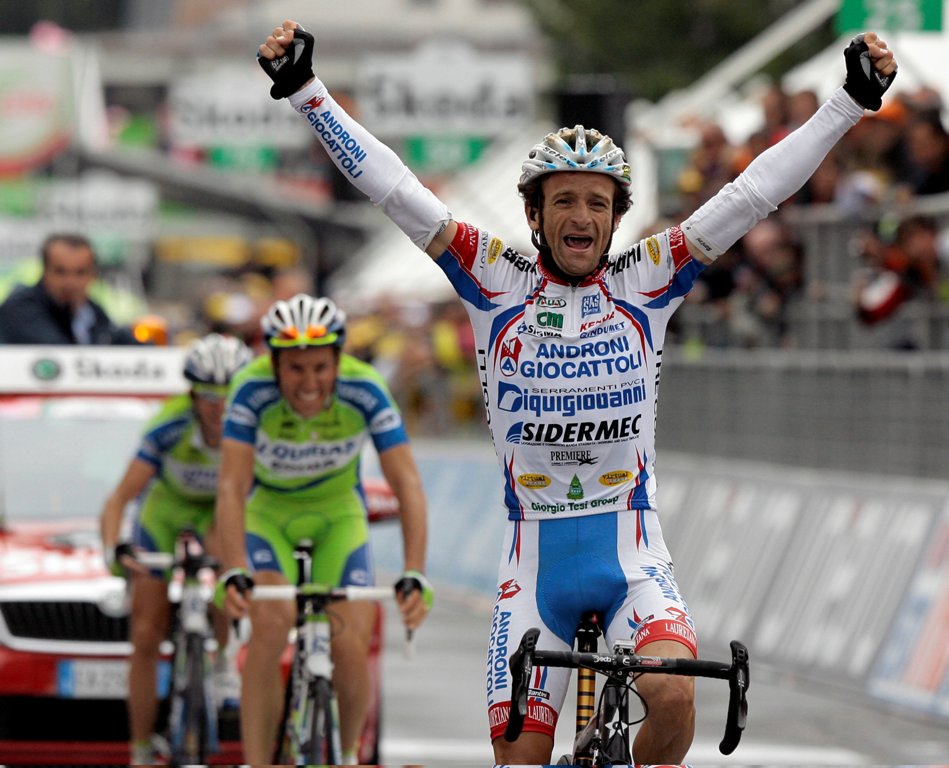 Androni-Diquigiova team rider Michele Scarponi of Italy celebrates his victory as he crosses the finish line ahead of Liquigas team riders Ivan Basso (C) and Vincenzo Nibali, both of Italy, during the 195-km 19th stage of the Giro d'Italia cycling race fr
